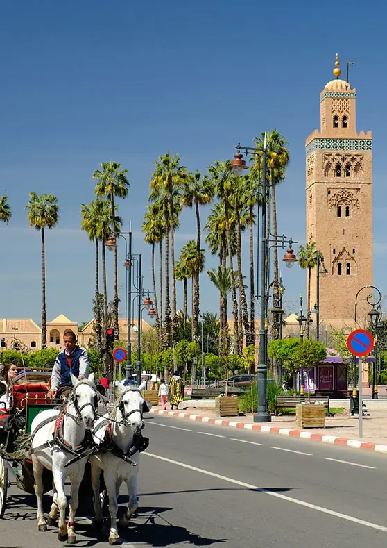Minarete de la Koutoubia y avenida con palmeras en Marrakech