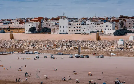 Playa y ciudad en la costa de Marruecos, con bañistas en la orilla