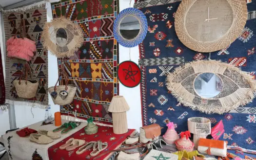Puesto de artesanía marroquí con alfombras, cestas y espejos
