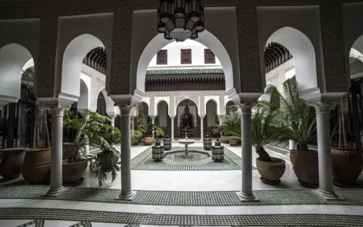Patio de palacio oriental con arcos, mosaico en el suelo y fuente central