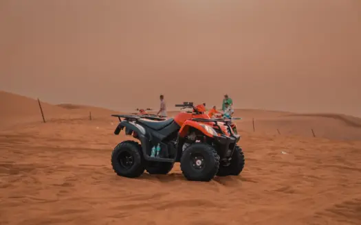 Quad sobre las dunas de un desierto bajo un cielo despejado