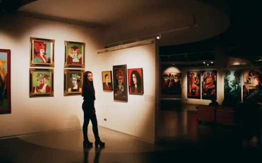 Una mujer contempla cuadros de colores en una exposición de arte contemporáneo