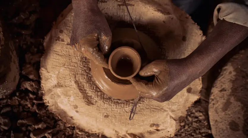 Manos moldeando barro en el torno de un alfarero de Marrakech