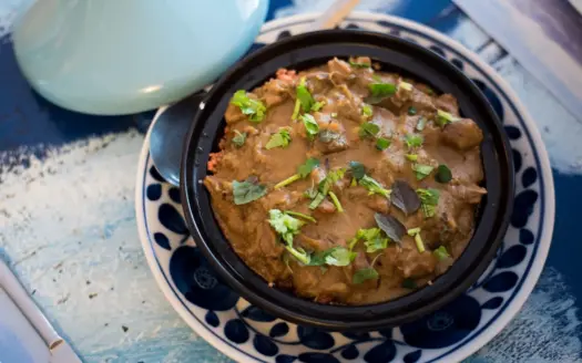Tajine marroquí con hierbas frescas, servido en su plato tradicional