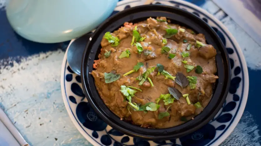 Tajine marroquí con hierbas frescas, servido en su plato tradicional