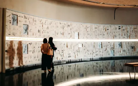 Dos personas observan unos dibujos en una galería de arte contemporáneo