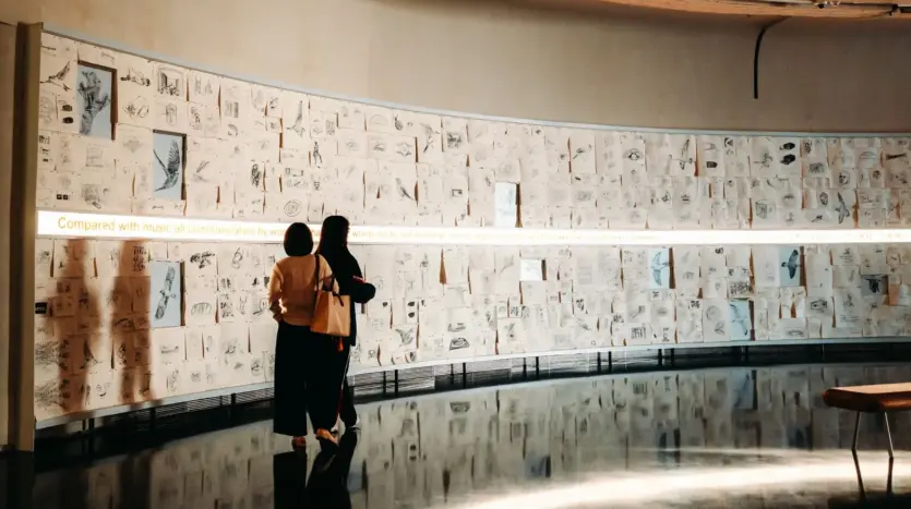 Dos personas observan unos dibujos en una galería de arte contemporáneo