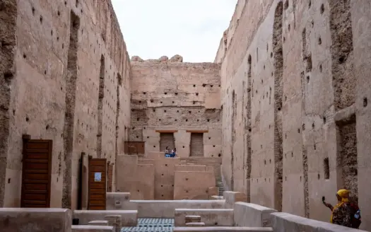 Visitantes recorren los muros históricos del palacio El Badi, en Marrakech