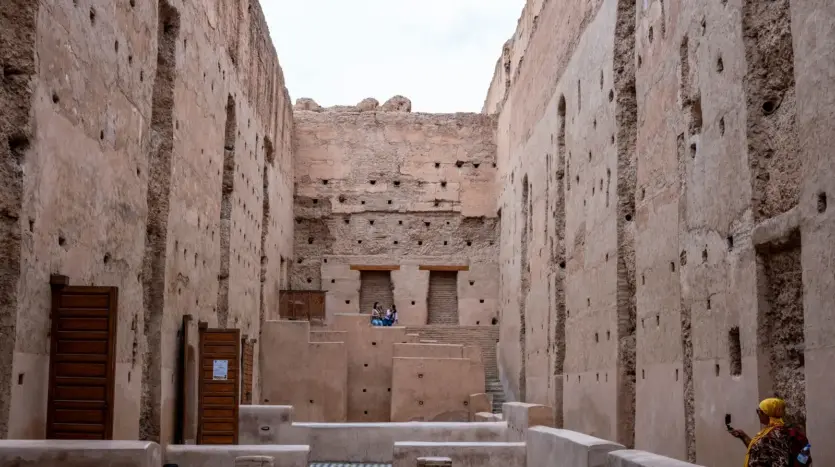 Visitantes recorren los muros históricos del palacio El Badi, en Marrakech