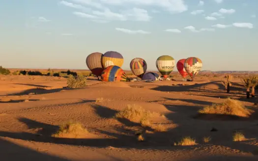 Globos aerostáticos elevándose sobre un paisaje desértico