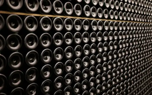 Hileras de botellas de vino apiladas de lado en una bodega