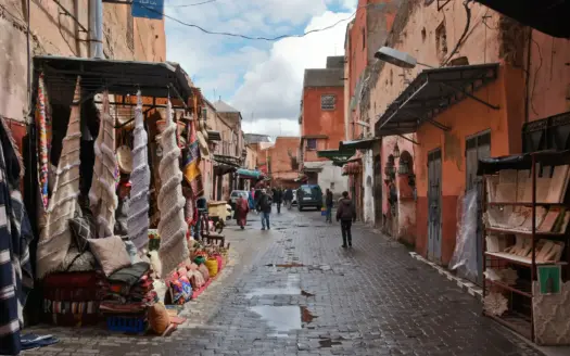 Calle de la medina con tiendas de mantas y textiles después de la lluvia