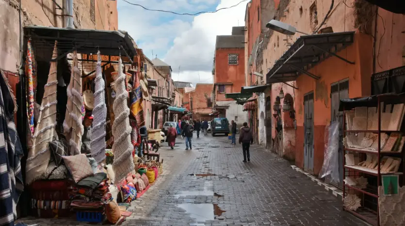 Calle de la medina con tiendas de mantas y textiles después de la lluvia