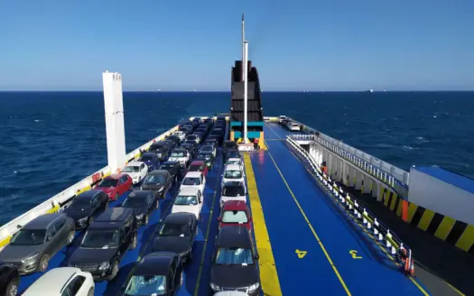 Coches aparcados en la cubierta de un ferry en alta mar, con el cielo despejado