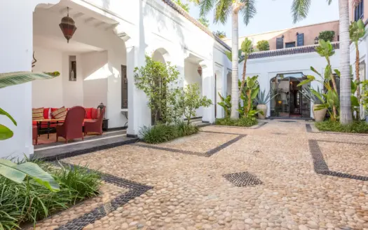 Patio de Villa Edith con plantas y arcadas