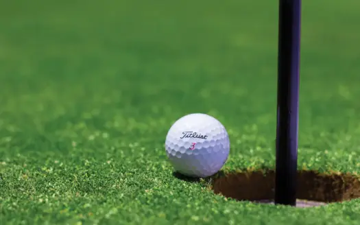Bola de golf junto al hoyo en un green